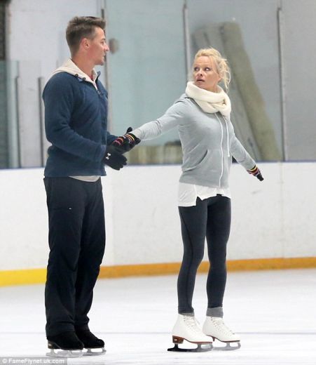 Seksbumba Pamela Andersone pieguļošā jaciņā trenējas dejot uz ledus